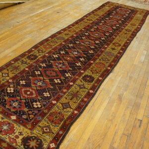 Detailed runner rug in dark red, navy, and gold tribal patterns on wide plank wood flooring.