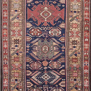 Low-pile runner with a navy field and repeating stylized geometric patterns in brick red, tan, and grey.