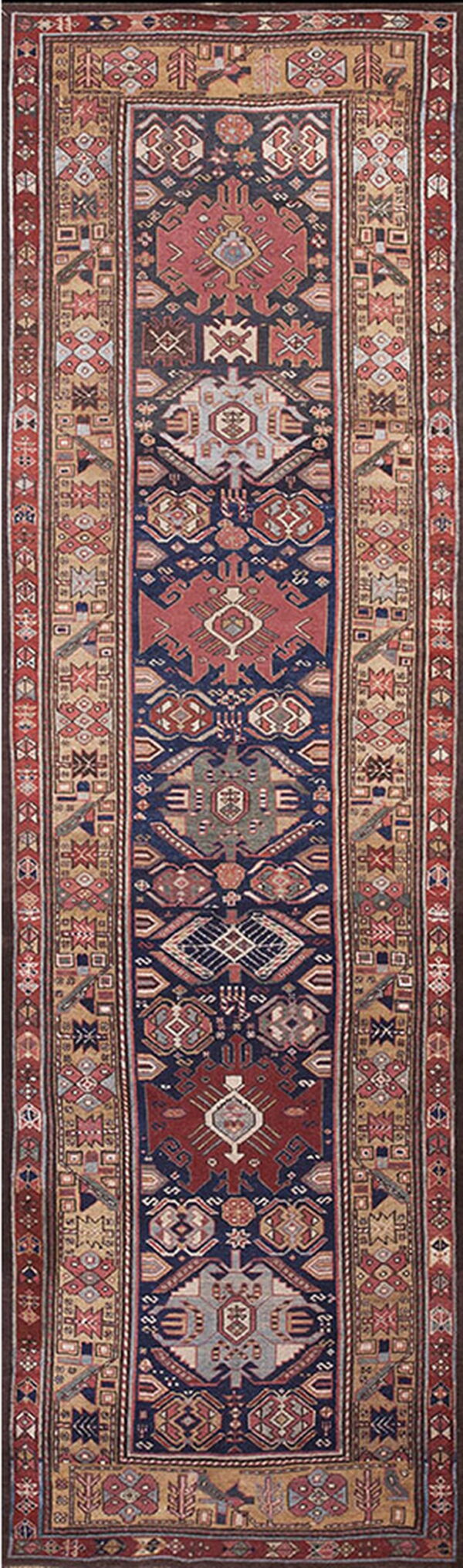 Low-pile runner with a navy field and repeating stylized geometric patterns in brick red, tan, and grey.