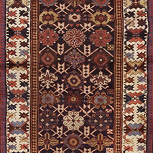 A traditional runner rug with a dark field, rust and gold motifs, and wide geometric borders in cream and dark blue.