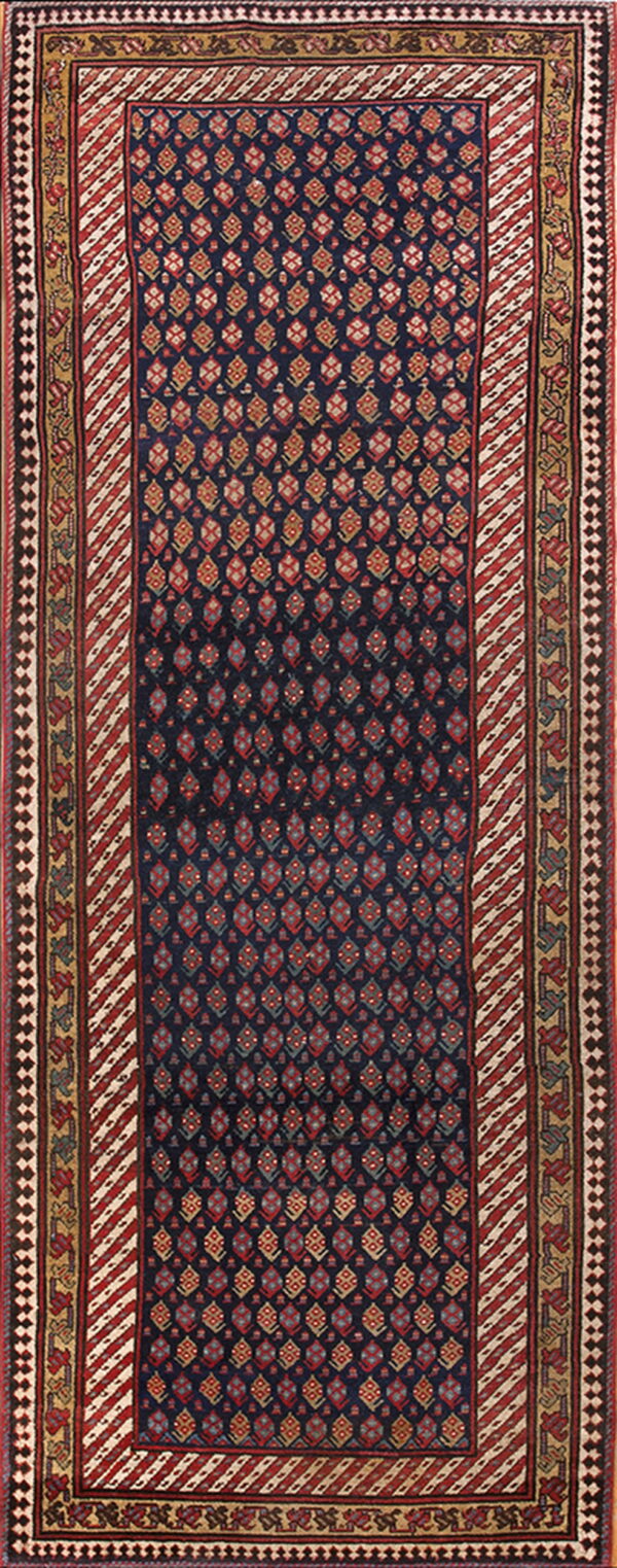 Navy runner rug with repeating red and tan motifs, framed by striped and patterned gold and rust borders.