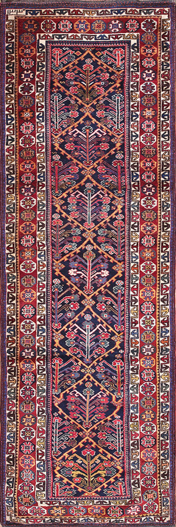Traditional runner rug featuring a dense navy geometric field bordered by complex red and ivory patterns.