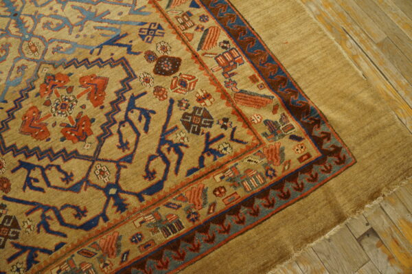 Rare collectable tribal camel color late 19th century antique nw persian serab rug 3 A tan rug with blue and terracotta geometric patterns lies on distressed light brown wood flooring.