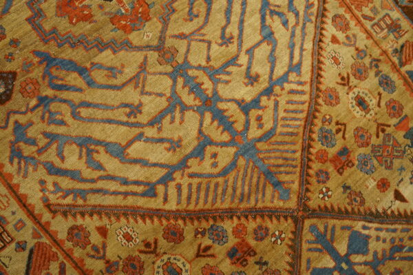 Rare collectable tribal camel color late 19th century antique nw persian serab rug 4 Geometric blue and red tribal patterns cover a textured golden tan rug field.