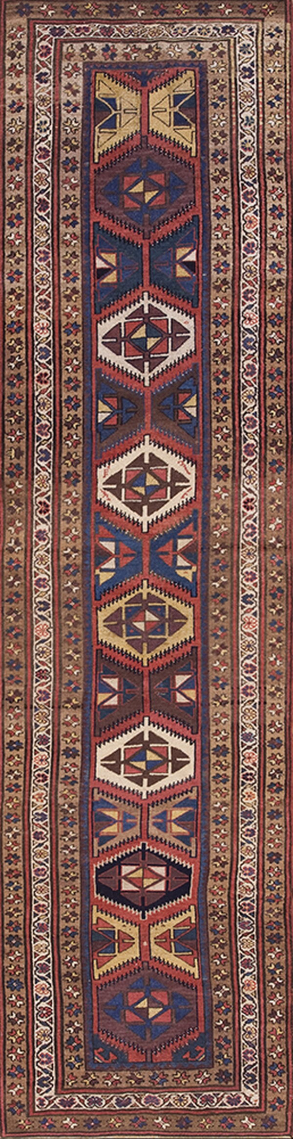 Long runner rug with repeating geometric medallions in red, brown, blue, and cream colors.