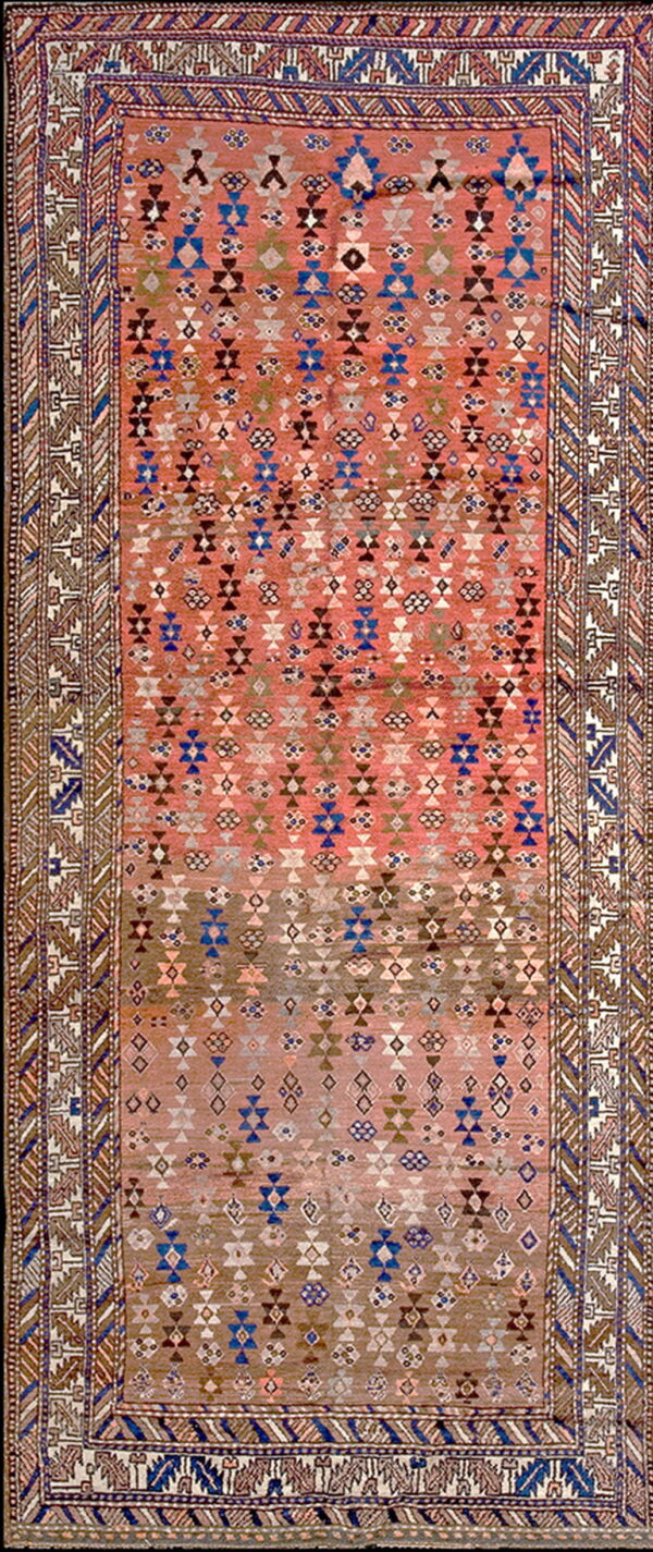 Geometric runner rug with pink and brown ground and repeating diamond patterns accented with blue and white.