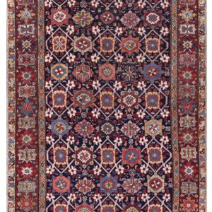 Traditional rug featuring an indigo field with colorful geometric medallions and a wide red border.