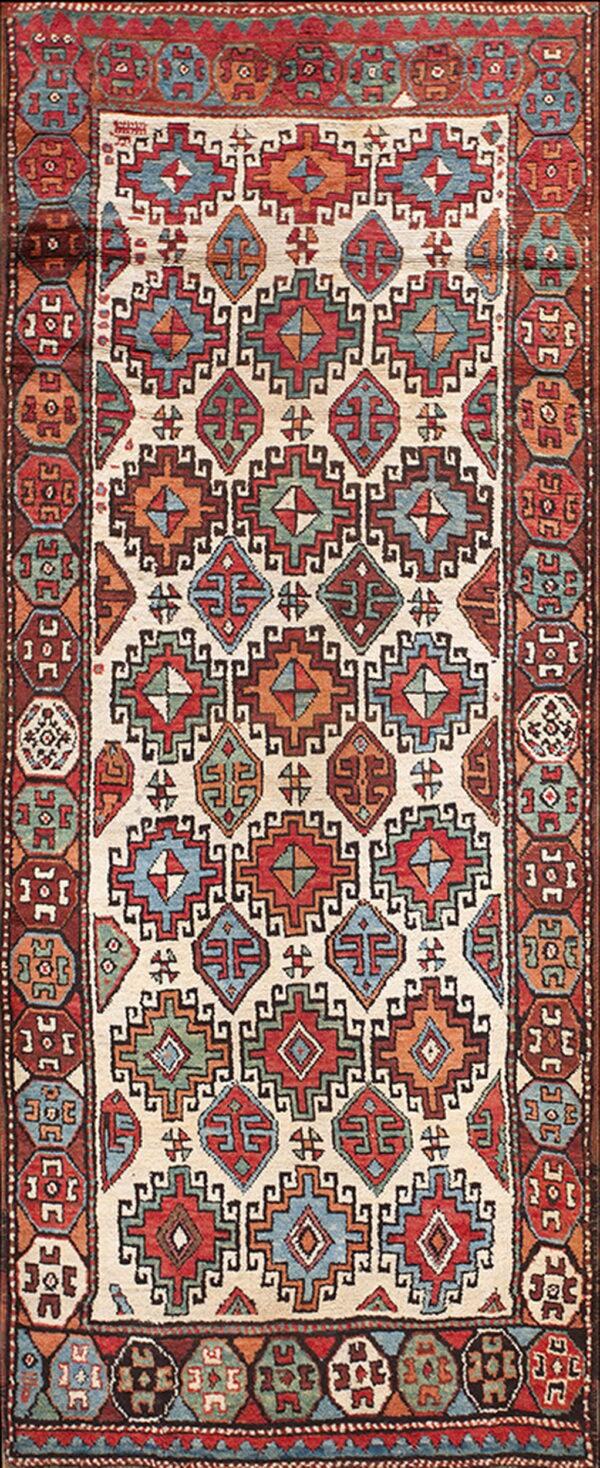 Ivory geometric rug with red, blue, and orange motifs and a border of repeating octagonal medallions.