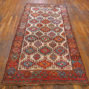 Low-pile geometric runner in cream, red, blue, and orange lying on rich hardwood floor planks.