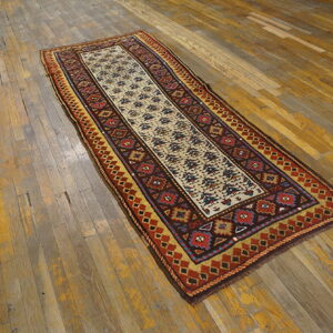 Geometric runner rug with cream, red, and gold patterns rests on distressed wooden floorboards.
