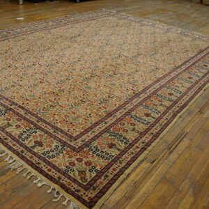 Multi-colored floral patterned rug with a cream field and dark borders displayed on plank hardwood floors.