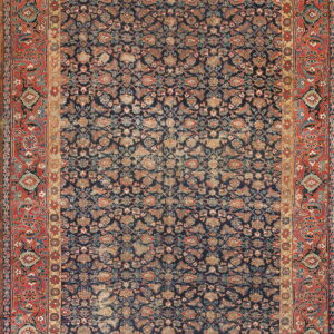 Full view of a distressed rug featuring a dense floral navy field and a wide red border.