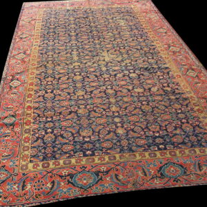 Detailed blue and rust rug with an overall repeating floral pattern against a solid black background.