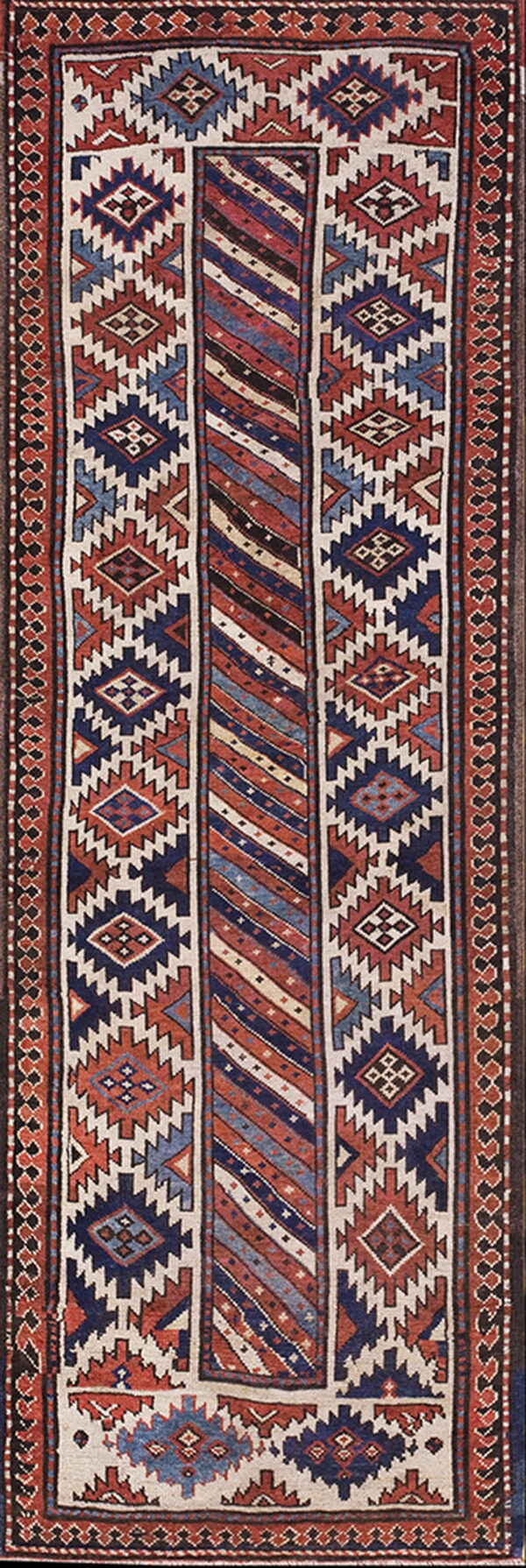 Geometric runner rug featuring blue, rust, cream, and black colors in a complex striped and diamond design.