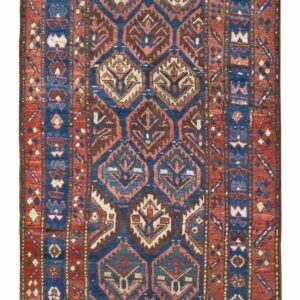 Geometric runner rug with stacked medallion patterns in blue, red, brown, and cream.