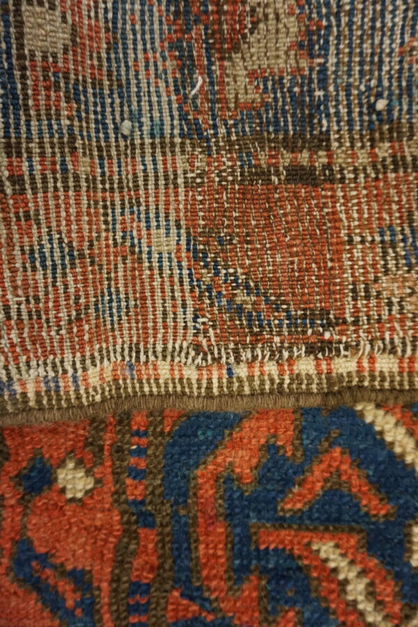 Close-up of blue, red, and brown woven fibers transitioning from flat texture to a dense geometric pile.