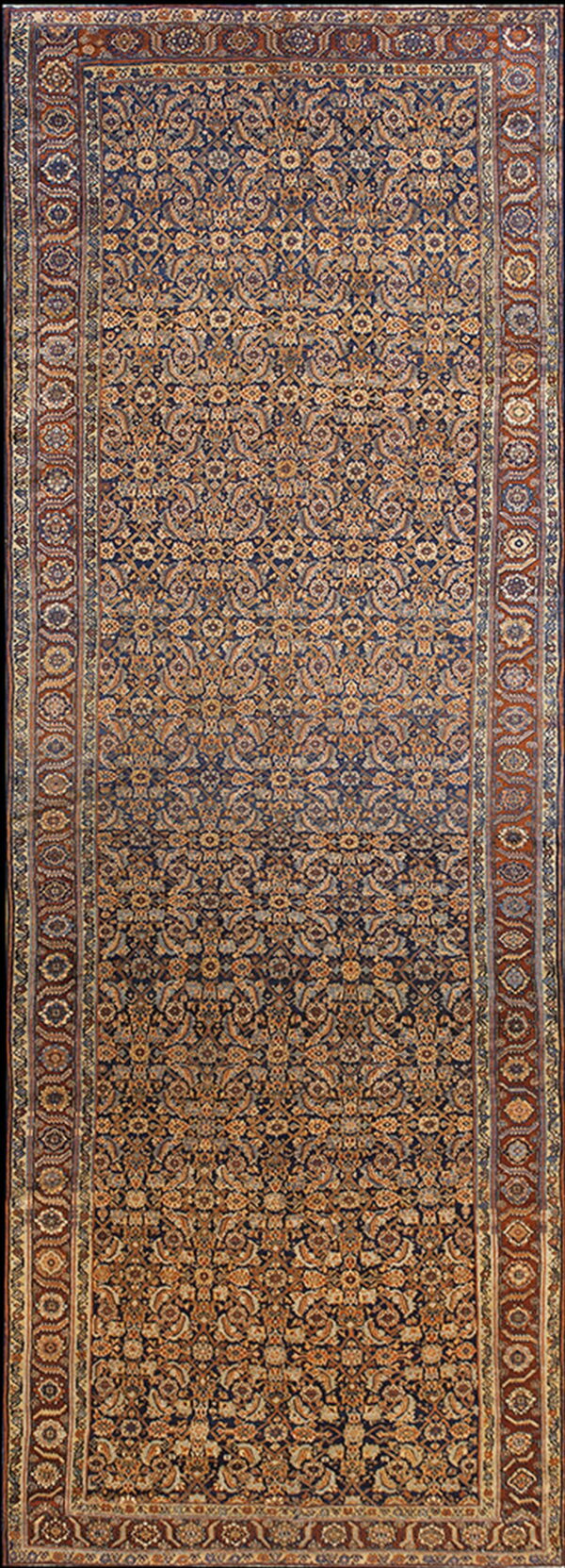 Narrow runner rug displaying dense gold and beige floral motifs on a dark blue ground, framed by rust borders.