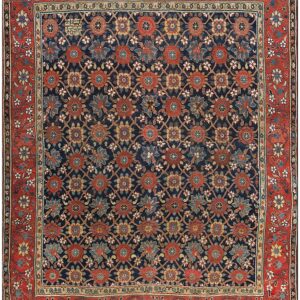Dark blue rug featuring a repeating floral trellis design in red, blue, and ochre, surrounded by a wide rust-colored border.