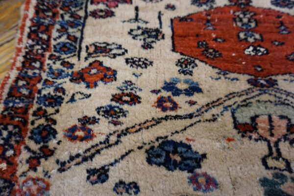 Textured beige rug with medium pile, featuring traditional floral motifs in red, navy blue, and black.