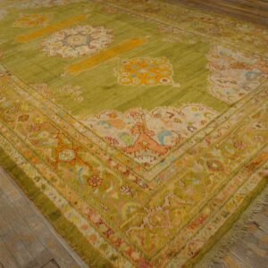 Green high-pile rug with yellow and light-colored traditional floral patterns on rustic wood floor.