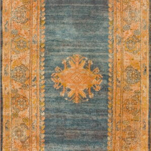 A distressed blue rug with a fading orange central medallion and wide patterned border.