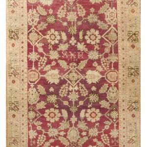 Ornate burgundy and cream rug featuring a dense floral pattern and a geometric-style wide border.