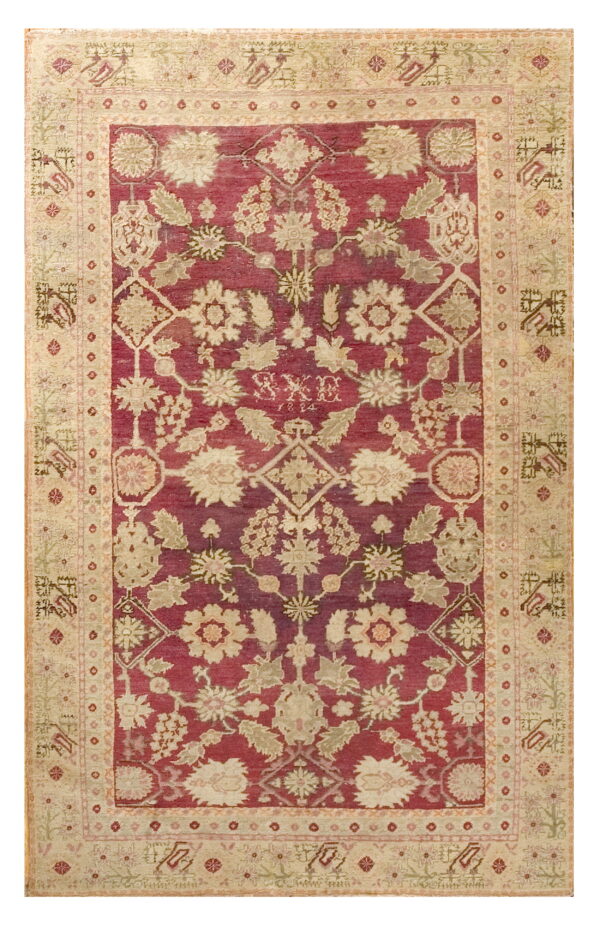 Ornate burgundy and cream rug featuring a dense floral pattern and a geometric-style wide border.