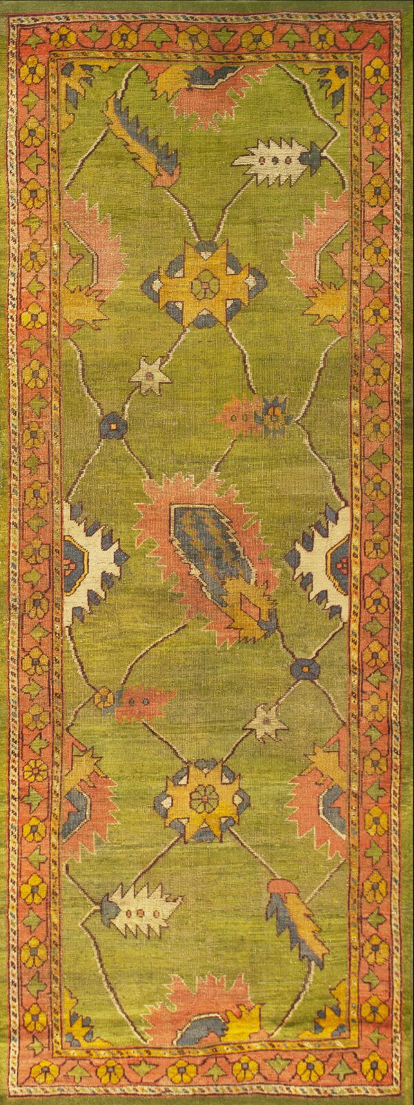 Runner rug featuring a lime green field with coral, yellow, and blue serrated floral medallions and a patterned border.
