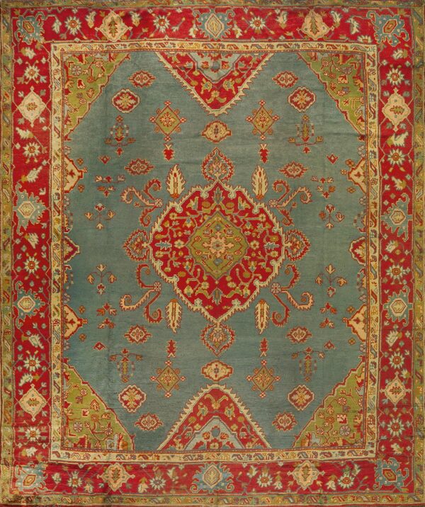 Traditional ornate rug with a blue field, red border, and complex floral medallion design.