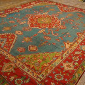 Traditional flatweave rug in vibrant teal, red, and lime green patterns rests on yellow hardwood flooring.