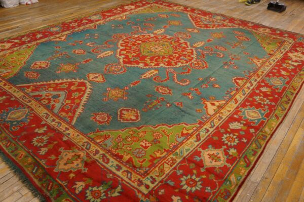 Traditional flatweave rug in vibrant teal, red, and lime green patterns rests on yellow hardwood flooring.