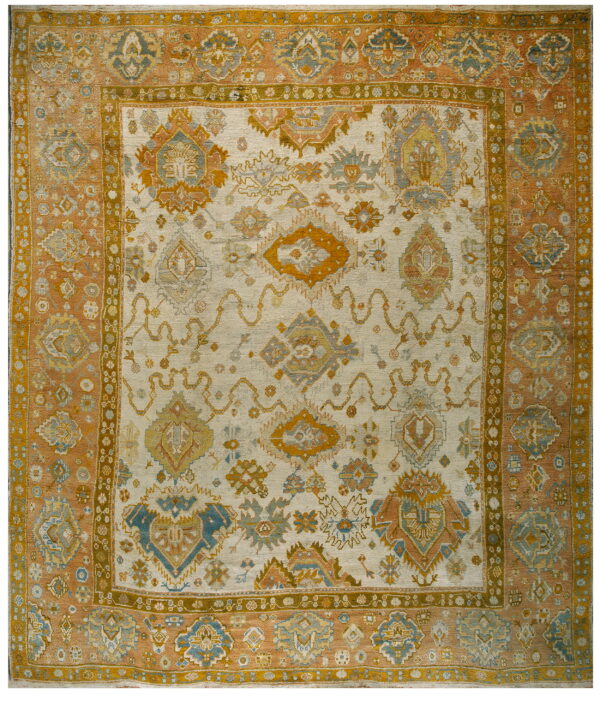 Low-pile rug with geometric patterns in cream, rust, gold, and muted blue tones.