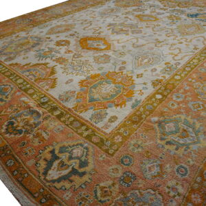 Square-format rug featuring a distressed traditional pattern in rust, mustard, sage, and pale beige.