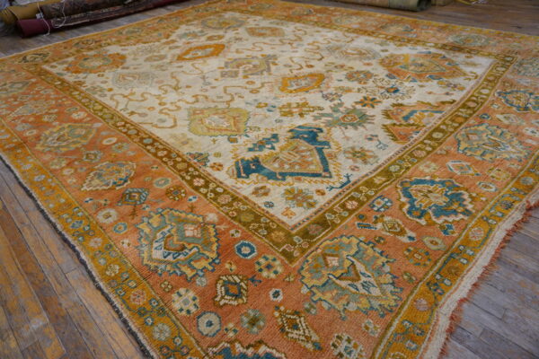 Low-angle view of a large rug featuring terracotta, cream, and teal patterns on wooden planks.
