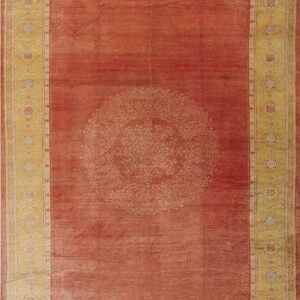 Rust red rug featuring a large central medallion and wide golden-yellow borders with repeating floral motifs.
