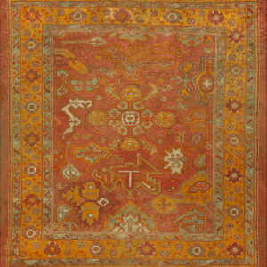 Rust-colored tribal rug with geometric patterns in gold, sage green, and cream accents.