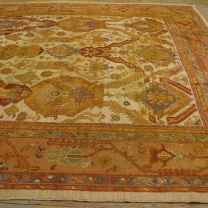 Low-pile rug featuring complex traditional patterns in cream, rust, gold, and pale green on wood flooring.