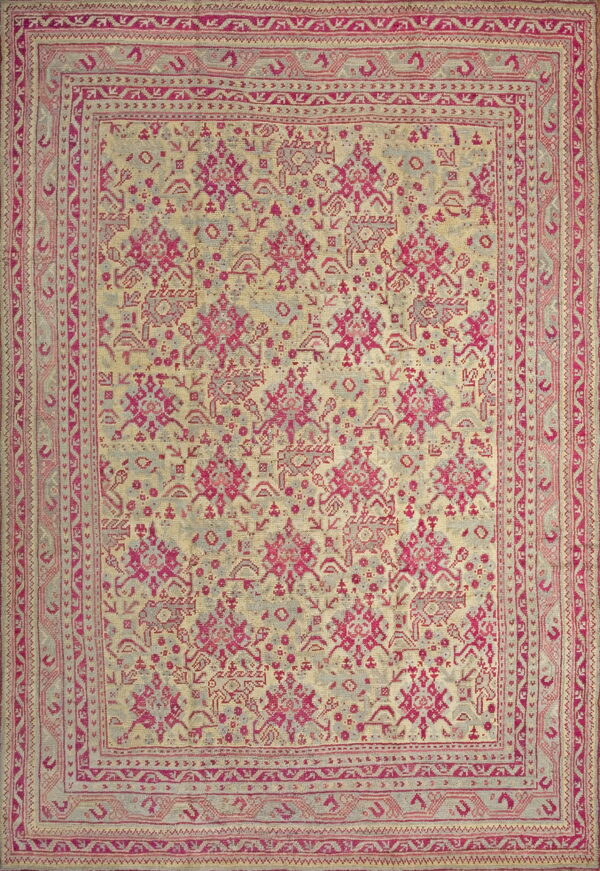 A rectangular rug featuring bright pink and gray geometric motifs on a pale yellow background.