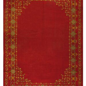 Solid crimson rug with a contrasting ornate geometric border pattern in green, gold, and gray tones.