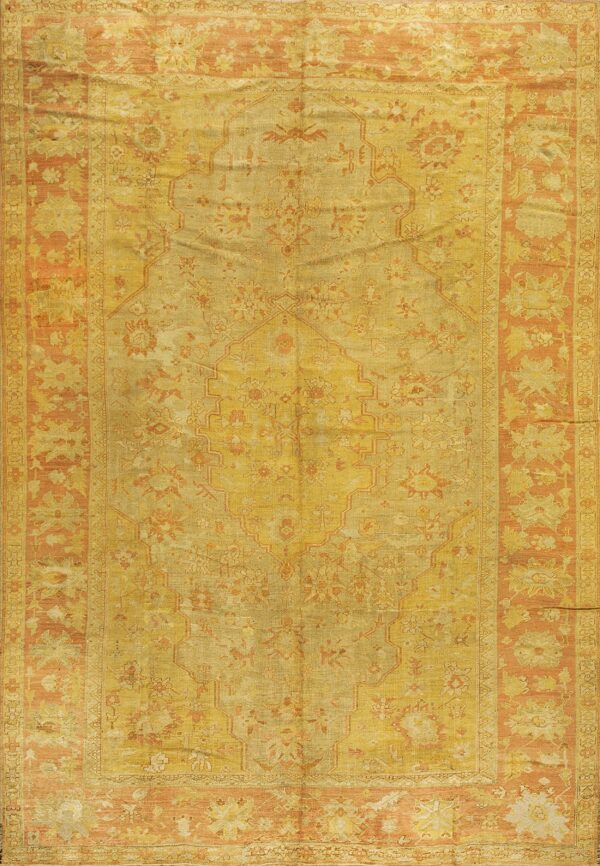 Distressed traditional rug featuring a central medallion pattern in faded gold, ochre, and apricot colors.