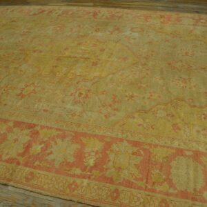 Muted yellow rug with faded coral medallion patterns and a ribbed texture rests on wood flooring.