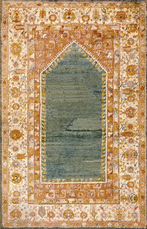 Low-pile rug with a blue-green arched central field surrounded by floral borders in orange and cream.