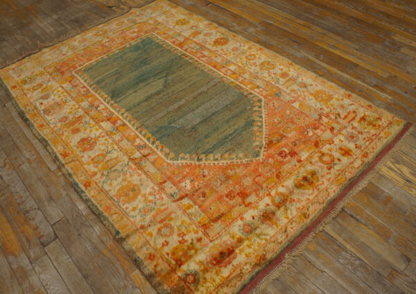 High-pile orange, cream, and teal floral rug with a central panel on rustic wood plank flooring.