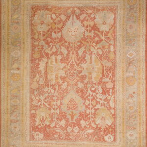 Traditional area rug with a faded rust field, gold accents, and complex borders in pale gray.