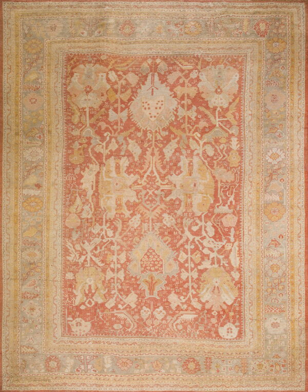 Traditional area rug with a faded rust field, gold accents, and complex borders in pale gray.