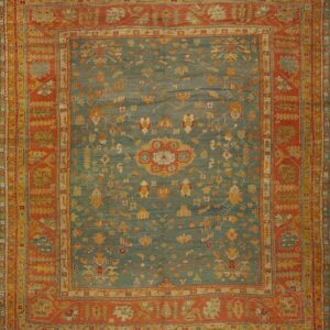Low-pile rug with a teal abrash field and complex stylized florals inside wide rust and gold borders.
