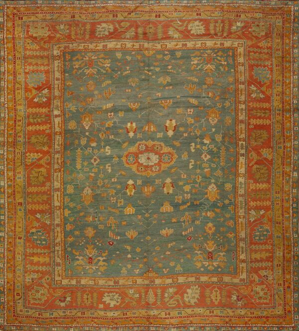 Low-pile rug with a teal abrash field and complex stylized florals inside wide rust and gold borders.