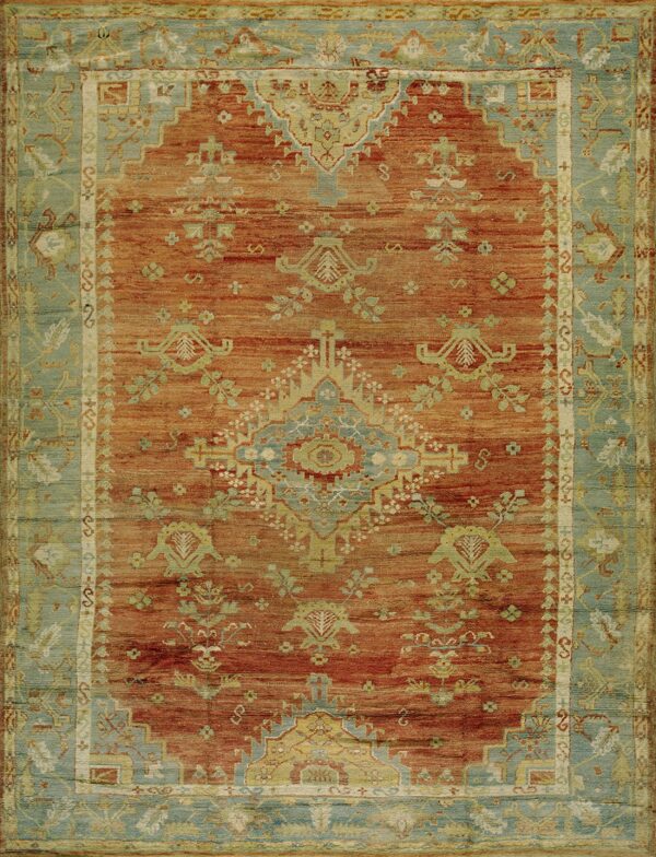 Rust orange rug with a traditional medallion and patterned dusty teal border.