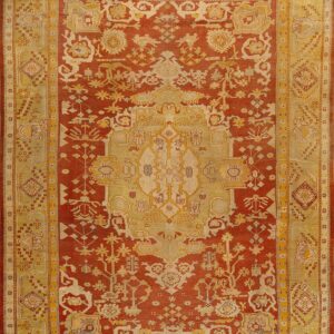 Red and gold traditional rug featuring a detailed central medallion and wide, patterned borders.