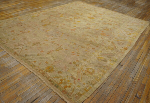 Faded ivory rug with floral patterns.